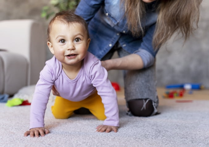 Baby Crawling on Carpet with Mother assistance