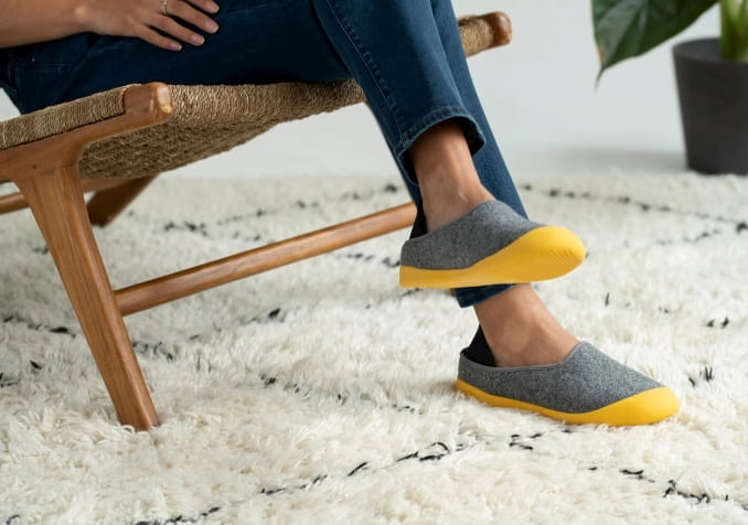 Man sitting with grey and yellow slipper 