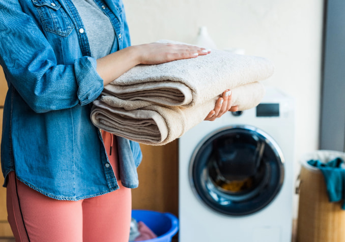 A is Woman Holding a Folding Clean Towel
