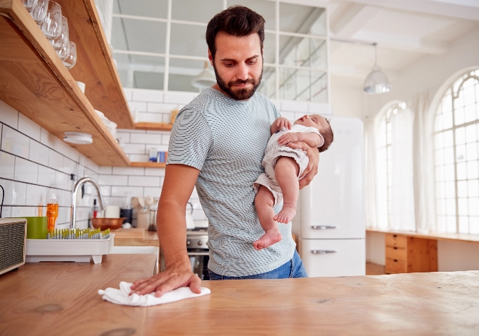 Man Carrying a Baby while Cleaning