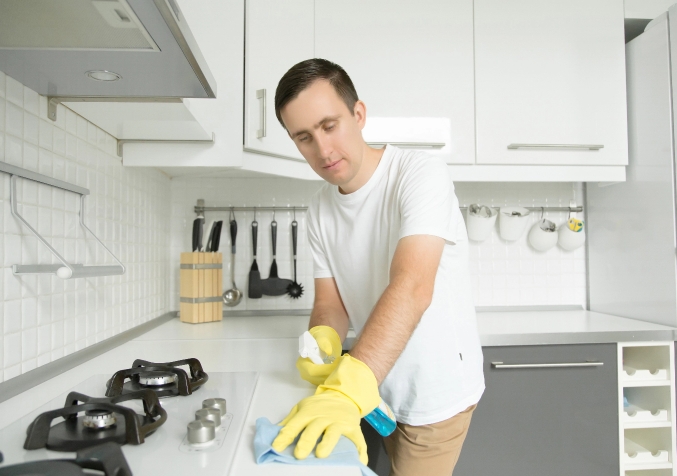 Man Cleaning Kitchen Stove
