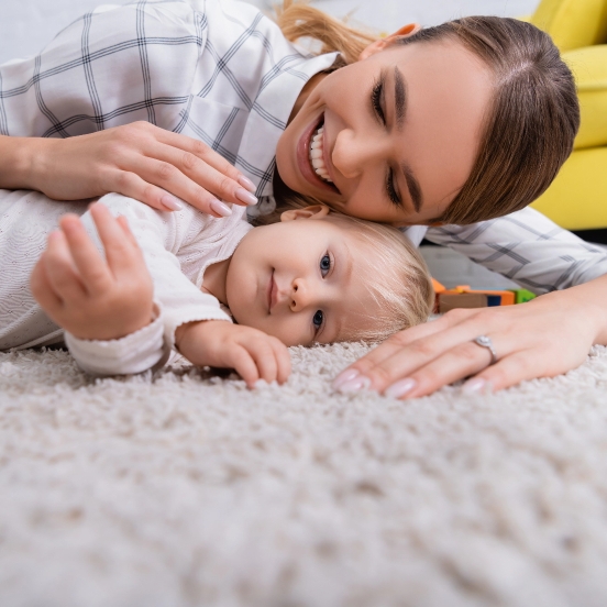 mother and Baby lying down on newly cleaned and disinfected carpet