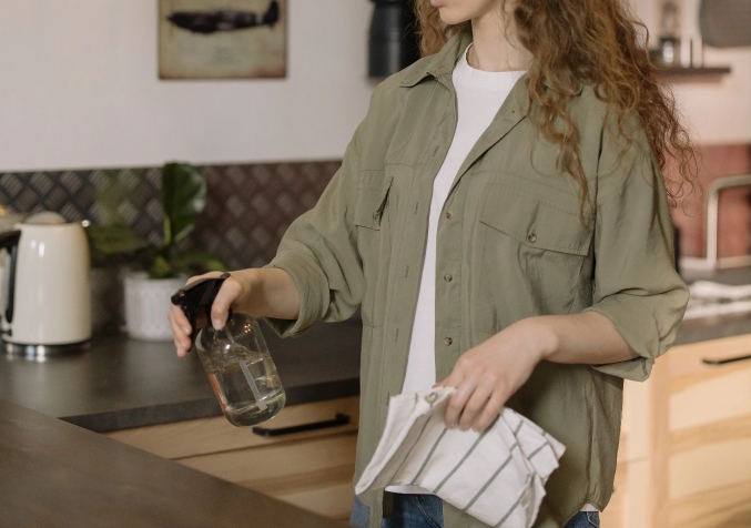 woman spraying water on the kitchen counter