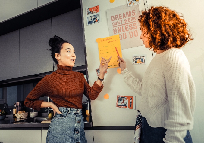 Smiling Roommates scheduling their household task together